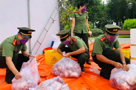 Chiến sĩ Công an tỉnh Đồng Nai chia thịt heo ra từng gói nhỏ trước khi đưa đi trao tặng người dân.