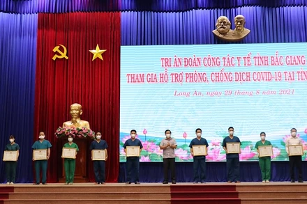 Chủ tịch UBND tỉnh Long An Nguyễn Văn Út trao bằng khen cho các cá nhân đã có thành tích đóng góp cho công tác phòng, chống dịch Covid-19 tại Long An.
