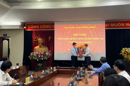 Đồng chí Nguyễn Trọng Nghĩa trao quyết định và tặng hoa, chúc mừng đồng chí Lê Hải Bình.