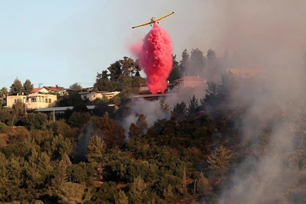 Máy bay rải chất dập lửa gần làng Beit Meir, ngoại ô Jerusalem, ngày 16/8. (Ảnh: Reuters)