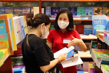 Phụ huynh lựa chọn sách giáo khoa tại hệ thống nhà sách của Nhà xuất bản Giáo dục Việt Nam. (Ảnh: Thành Tùng)