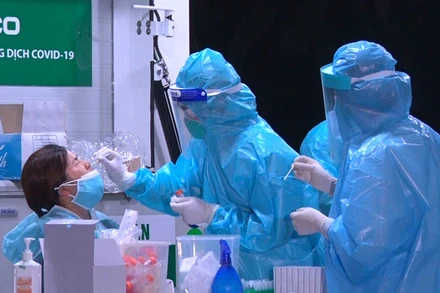 Cán bộ y tế lấy mẫu xét nghiệm của công dân về từ Nhật Bản.