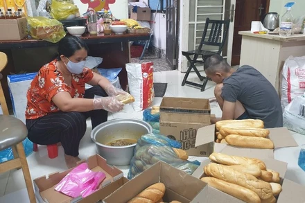 Một nhóm thiện nguyện chuẩn bị các suất ăn cho lực lượng tuyến đầu tại bệnh viện dã chiến.