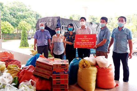 Chủ tịch Hội Nông dân tỉnh Lào Cai (người cầm biển, đứng giữa) tại buổi quyên góp, ủng hộ lương thực, rau xanh giúp người dân TP Hà Nội.