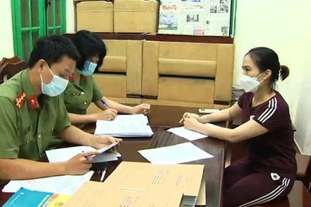 Đối tượng Hoàng Thị Thanh Nga làm việc với cơ quan điều tra. (Ảnh: Liên Liên)