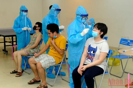 Lấy mẫu xét nghiệm Covid-19 cho nhân viên bảo vệ bán hàng siêu thị Co.op mart Vĩnh Hưng, quận Hoàng Mai. (Ảnh: Đăng Khoa)