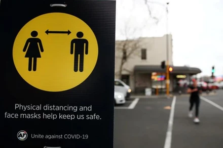 Biển nhắc người dân đeo khẩu trang và giãn cách để bảo đảm an toàn. (Ảnh: Reuters)