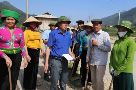 Ông Lò Văn Pháng (đứng giữa áo xanh) vận động người dân làm đường giao thông nông thôn.