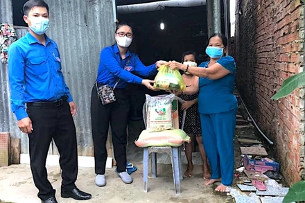 Đội hình áo xanh tình nguyện miệt rừng U Minh hạ hỗ trợ mang thực phẩm xuống nhà dân.
