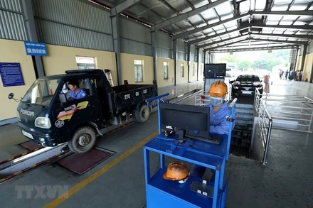 Kiểm tra kỹ thuật của các phương tiện vào kiểm định. (Ảnh: TTXVN)