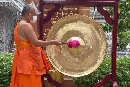 Một nhà sư Campuchia đánh cồng nhắc nhở người dân phòng, chống dịch (Ảnh: Fresh News).