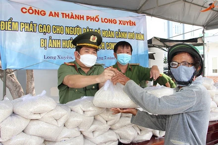 Đại tá Đinh Văn Nơi, Giám đốc Công an tỉnh An Giang trực tiếp trao tặng gạo cho người dân gặp khó khăn do dịch bệnh.