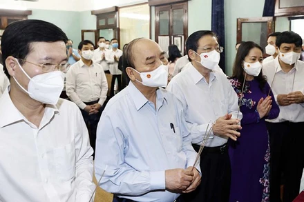 Chủ tịch nước Nguyễn Xuân Phúc và các thành viên trong đoàn thành kính dâng hoa, dâng hương tại Nhà 67. (Ảnh: TTXVN)