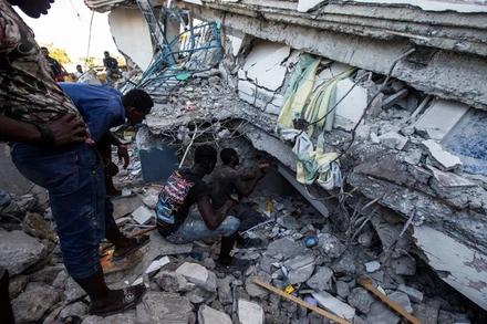 Người dân Haiti tìm kiếm người còn sống bị mắc kẹt trong ngôi nhà bị sập tại Les Cayes. (Ảnh: Reuters)