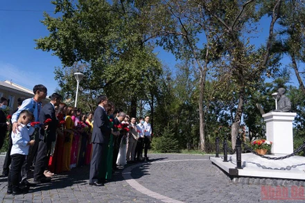 Người Việt Nam tại Vladivostok dâng hoa tại tượng đài Bác Hồ. (Ảnh: THANH THỂ)