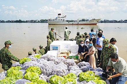 Cán bộ, chiến sĩ Vùng 2 Hải quân vận chuyển nông sản bằng đường thủy từ Đồng Tháp về TP Hồ Chí Minh.