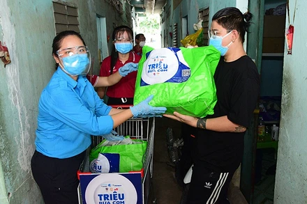 Tình nguyện viên trao nhu yếu phẩm của chương trình “Triệu bữa cơm” tặng ngươi dân có hoàn cảnh khó khăn tại TP Hồ Chí Minh.