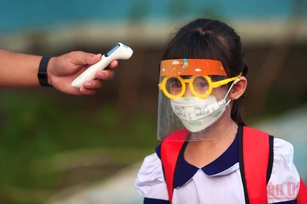 Đo thân nhiệt cho học sinh trước khi vào Trường tiểu học Thạnh An, huyện Cần Giờ, TP Hồ Chí Minh. (Ảnh: HẢI LONG)