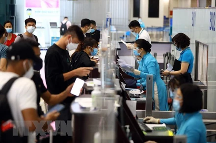 Hành khách phải tiêm đủ 2 mũi vaccine phòng Covid-19 sau 14 ngày hoặc có giấy xác nhận là F0 khỏi bệnh dưới 6 tháng và xuất trình kết quả xét nghiệm âm tính trong vòng 72 giờ trước khi lên máy bay. (Ảnh: Huy Hùng/TTXVN)