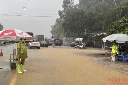 Lực lượng chức năng làm nhiệm vụ tại chốt kiểm soát dịch. (Ảnh: TRẦN HẢO)