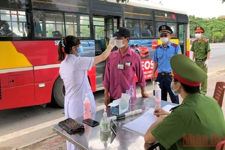 Cán bộ thanh tra giao thông cùng công an, y tế tại chốt kiểm soát dịch bệnh Xuân Phương (Phúc Yên, Vĩnh Phúc). (Ảnh: NGUYÊN LƯỢNG)