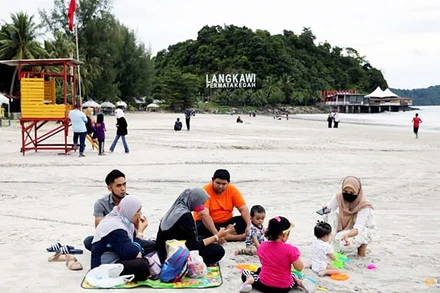 Du khách nghỉ ngơi trên bãi biển ở Langkawi theo mô hình "bong bóng du lịch" (Ảnh: REUTERS)