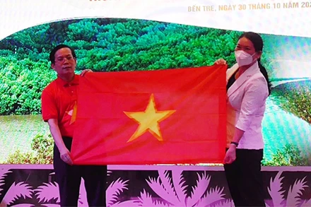 Phó Chủ tịch UBND tỉnh Bến Tre Nguyễn Thị Bé Mười nhận tượng trưng 10 nghìn lá cờ Tổ quốc từ lãnh đạo báo Người Lao Động.