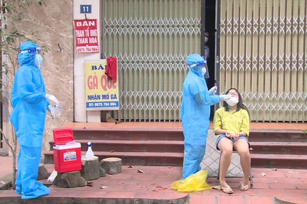 Cán bộ y tế lấy mẫu xét nghiệm cho F0 điều trị tại nhà.