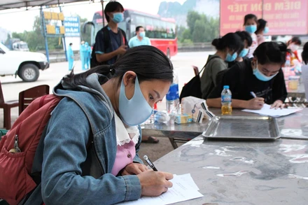 Công nhân hồi hương khai báo y tế tại điểm đón, tiếp ở xã Trường Lâm, thị xã Nghi Sơn.