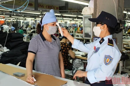 Kiểm tra thân nhiệt người lao động ở Công ty Tiên Sơn. (Ảnh: MAI LUẬN)