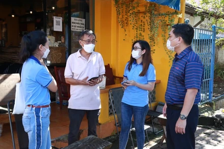 Lãnh đạo TP Long Khánh (Đồng Nai) cùng tình nguyện viên hướng dẫn ông Nguyễn Anh Tuấn sử dụng quét mã QR.