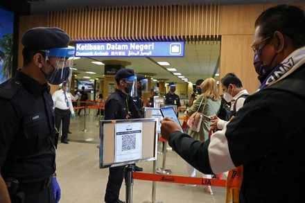 Khách du lịch quét mã QR để làm thủ tục tại sân bay khi Langkawi mở cửa trở lại cho du lịch nội địa, ngày 16/9/2021. (Ảnh: Reuters)