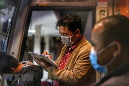 Nhân viên bến xe Mỹ Đình kiểm tra lại danh sách hành khách trước khi xuất bến ngày 14/10. (Ảnh: TTXVN)