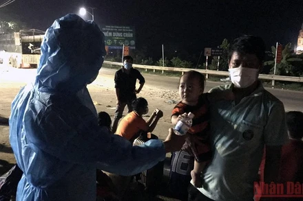 Cán bộ trạm kiểm dịch cầu Trì, huyện Bắc Quang (Hà Giang) hỗ trợ lao động từ vùng dịch về quê sáng 8/10. 