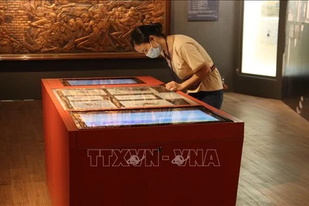 Khách tham quan trải nghiệm công nghệ tra cứu thông tin tại Bảo tàng phụ nữ Nam Bộ. Ảnh: TTXVN.
