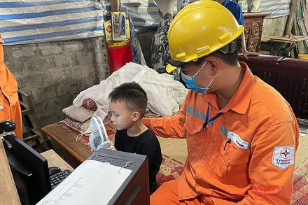 Các kỹ sư EVN Hà Nội vận chuyển thiết bị điện tử đến khu dân cư có hoàn cảnh khó khăn. 