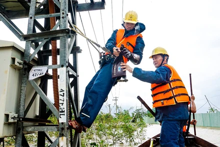 Công nhân điện lực Cẩm Lệ khắc phục sự cố ngay trong mưa bão.