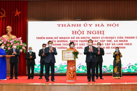 Bí thư Thành ủy Đinh Tiến Dũng và Trưởng Ban Tuyên giáo Trung ương Nguyễn Trọng Nghĩa trao bằng khen cho Ban Tuyên giáo Thành ủy Hà Nội. (Ảnh: Duy Linh) 