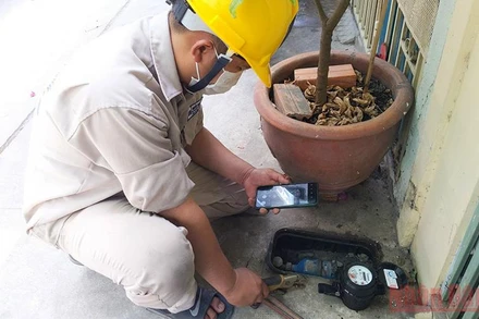 Nhân viên một Công ty cổ phần cấp nước tại TP Hồ Chí Minh kiểm tra đồng hồ nước tại nhà dân.