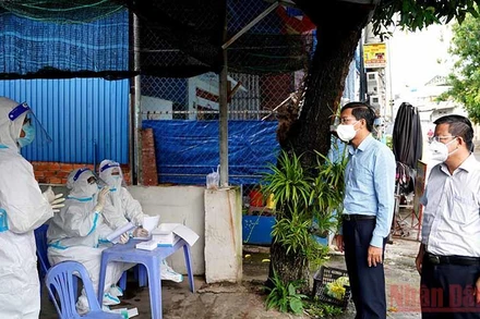 Chủ tịch UBND tỉnh Bình Thuận Lê Tuấn Phong (thứ hai, bên phải) kiểm tra một điểm lấy mẫu xét nghiệm SARS-CoV-2. (Ảnh: Hữu Tri)