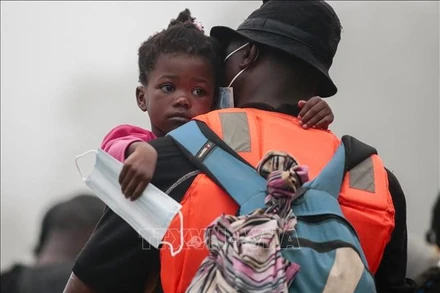 Người di cư mang theo con nhỏ được chuyển từ làng Bajo Chiquito tới trạm tiếp nhận ở Lajas Blancas, tỉnh Darien, Panama ngày 31/8. Ảnh: AFP/TTXVN.