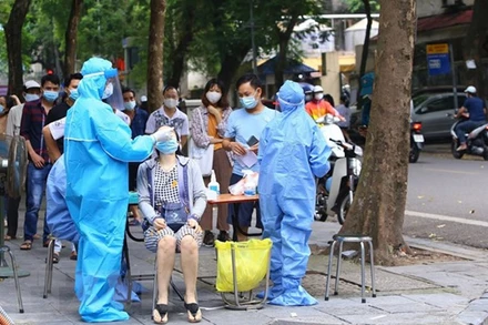 Triển khai lấy mẫu xét nghiệm cho người dân quanh khu vực Bệnh viện Việt Đức (Ảnh: TTXVN)