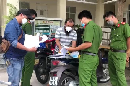 Trần Xuân Đạt (áo sọc ngang), đối tượng chính trong đường dây làm Giấy xét nghiệm Covid-19 giả. 