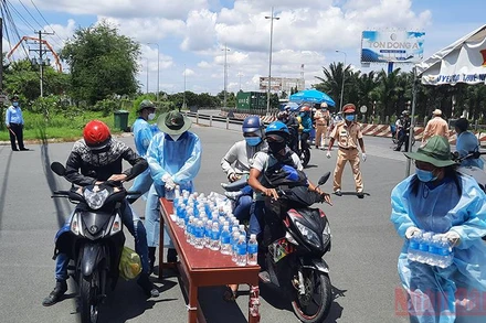 Tuổi trẻ Vĩnh Long hỗ trợ nước uống cho những người dân ngoài tỉnh tại chốt kiểm soát dịch bệnh số 1. (Ảnh: Bá Dũng)