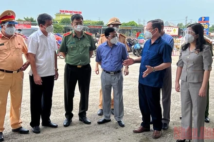 Lãnh đạo Trung tâm Y tế thị xã Nghi Sơn báo cáo thực thi các biện pháp phòng, chống dịch tại khu vực chốt kiểm soát Khe nước lạnh. (Ảnh: MAI LUẬN) 