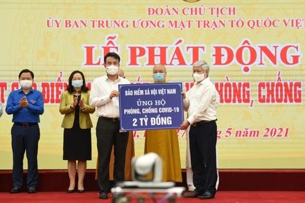 Chủ tịch Ủy ban T.Ư MTTQ Việt Nam Đỗ Văn Chiến tiếp nhận hai tỷ đồng do Tổng Giám đốc BHXH Việt Nam Nguyễn Thế Mạnh - thay mặt toàn thể CCVC ngành BHXH Việt Nam ủng hộ phòng, chống dịch Covid-19. Ảnh: TÂM TRUNG