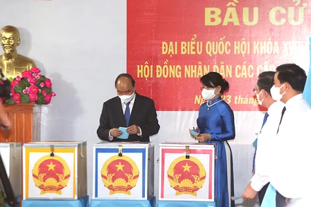 Chủ tịch nước Nguyễn Xuân Phúc cùng phu nhân bỏ phiếu tại khu vực bỏ phiếu số 041, đơn vị bầu cử số 9, thị trấn Củ Chi, huyện Củ Chi, TP Hồ Chí Minh.