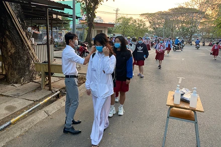 Đo thân nhiệt học sinh khi đến trường.