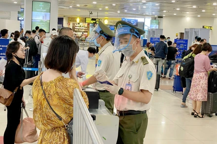 Lực lượng An ninh hàng không Nội Bài được trang bị đầy đủ găng tay, khẩu trang, tấm chắn giọt bắn trong khi tiếp xúc với hành khách. (Ảnh: NIA)