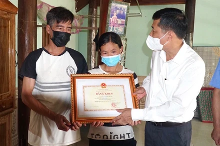 Trao Bằng khen của Bộ GD-ĐT cho gia đình em Lương Mạnh Tuấn. Ảnh: MH